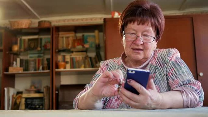 一位老年妇女在手机上写了一条短信。她小心翼翼地按下屏幕并发音