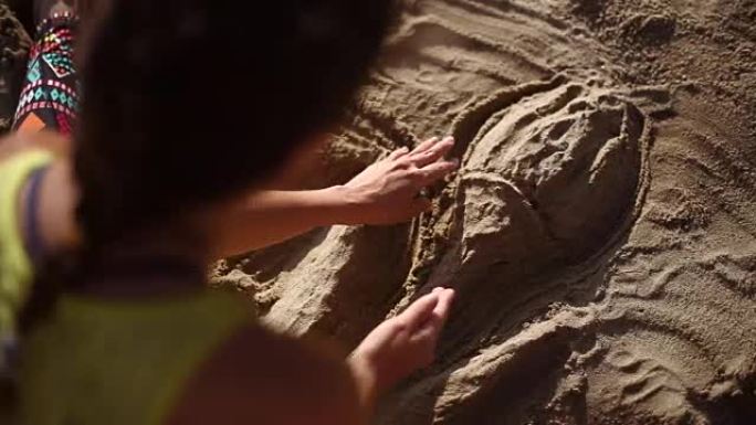 女孩在沙子里画画