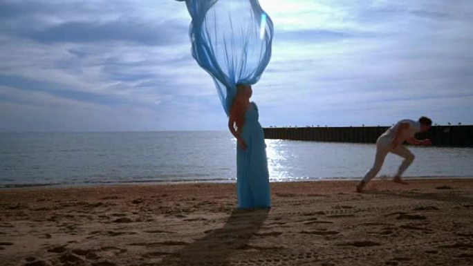 蓝布在海滩上飞翔的孕妇。怀孕概念