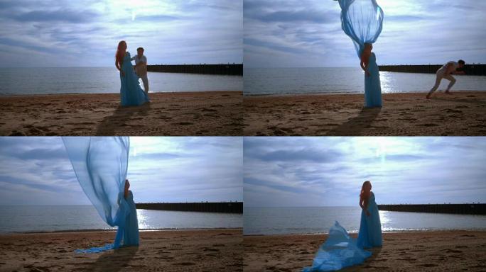 蓝布在海滩上飞翔的孕妇。怀孕概念