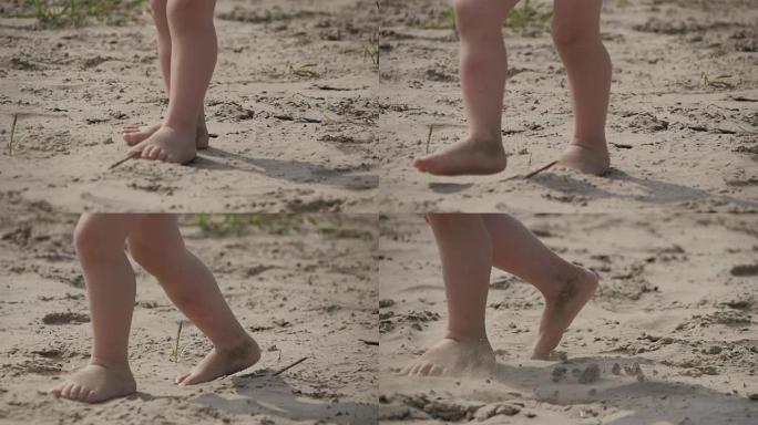 孩子们的腿在沙滩上奔跑