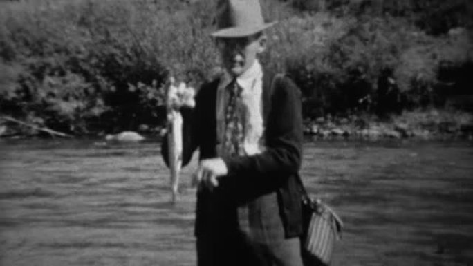 1939: 渔夫在快速溪流中涉水，显示鳟鱼捕获。
