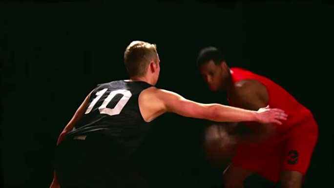 篮球运动员在黑色背景下捍卫对手