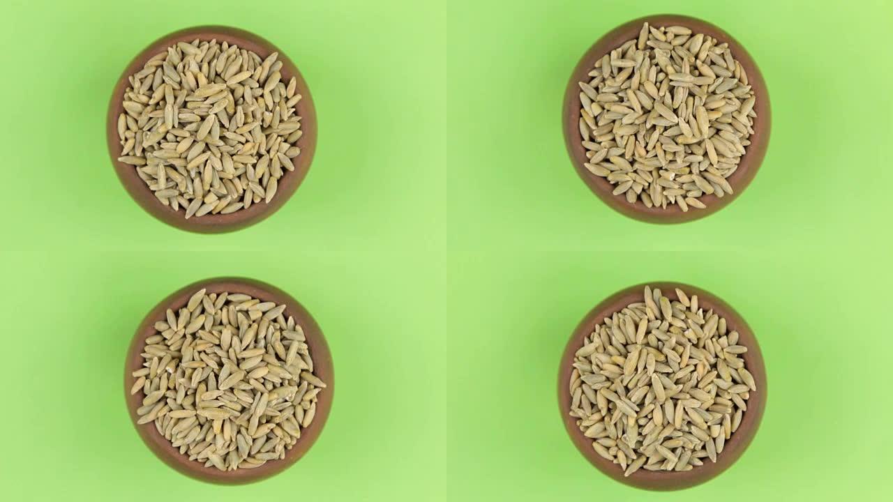 黑麦颗粒在绿色屏幕上隔离的锅中旋转。