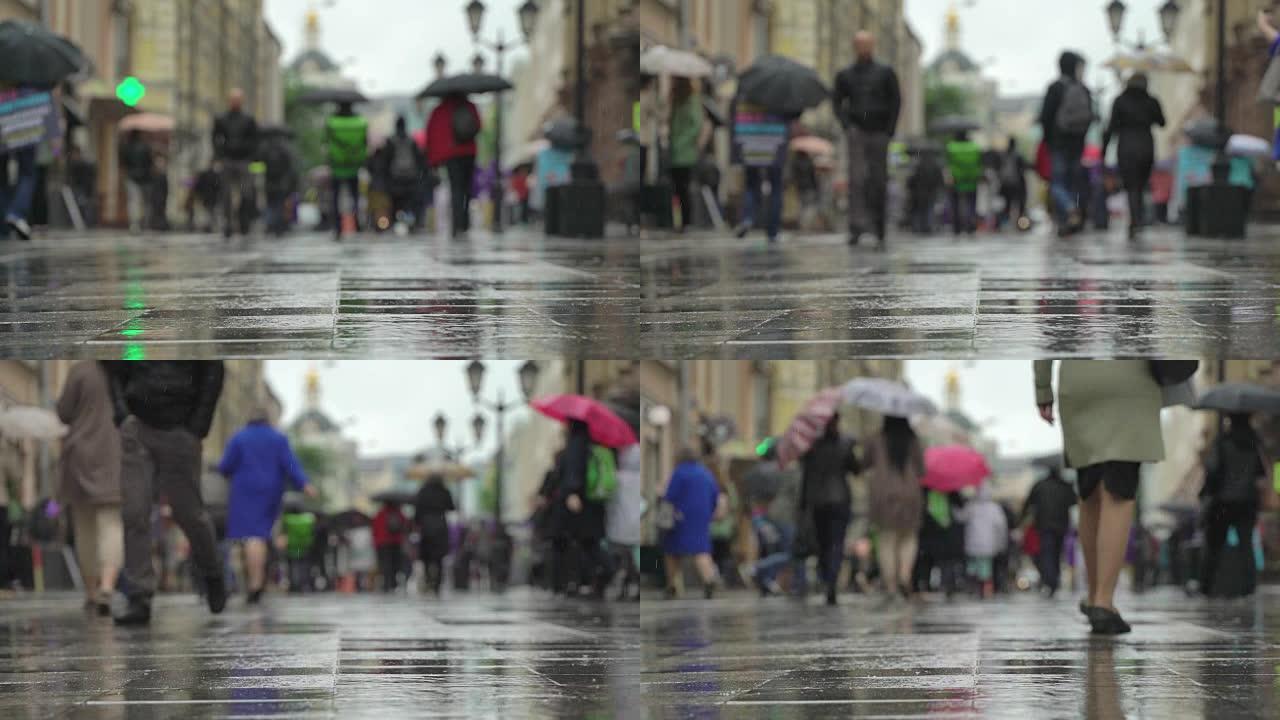 城市街道雨天的背景。实时。雨中带伞的人上下班。模糊的波克。自然背景