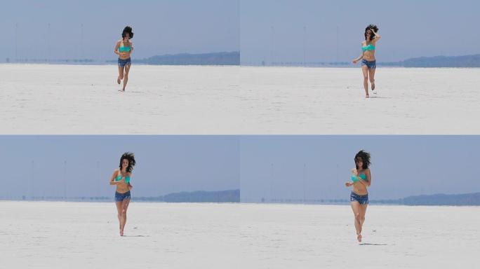 一名妇女在塞浦路斯一个非常白色的盐湖上奔跑
