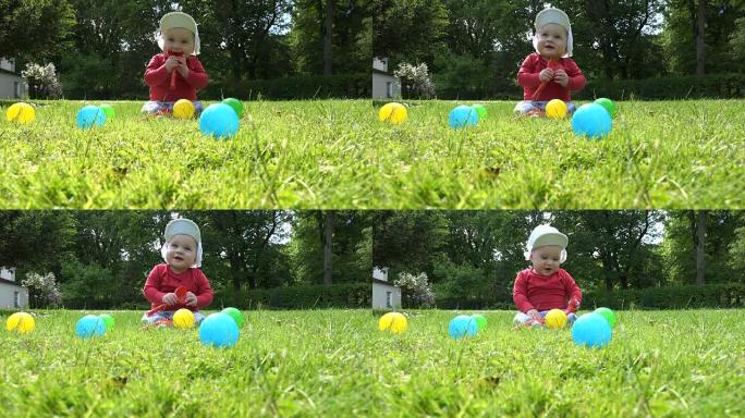 男婴坐在草地上，在五颜六色的球之间玩耍。