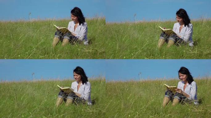 一名妇女在绿色草坪上阅读的慢动作视频