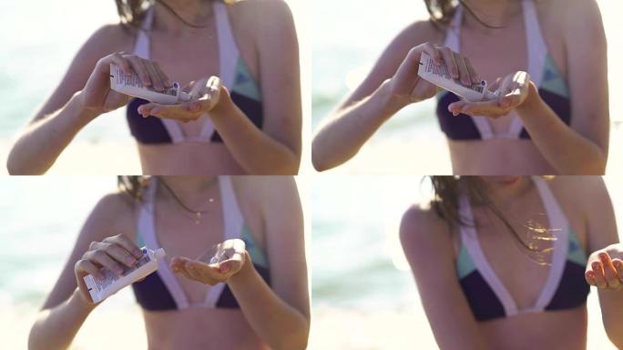 美容女孩在海滩上用瓶子里的防晒霜为身体涂防晒霜