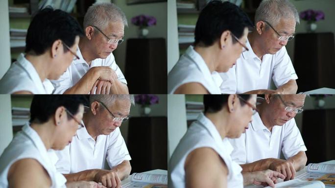 亚洲老年夫妇在小图书馆一起阅读书籍和杂志。学习和学习理念