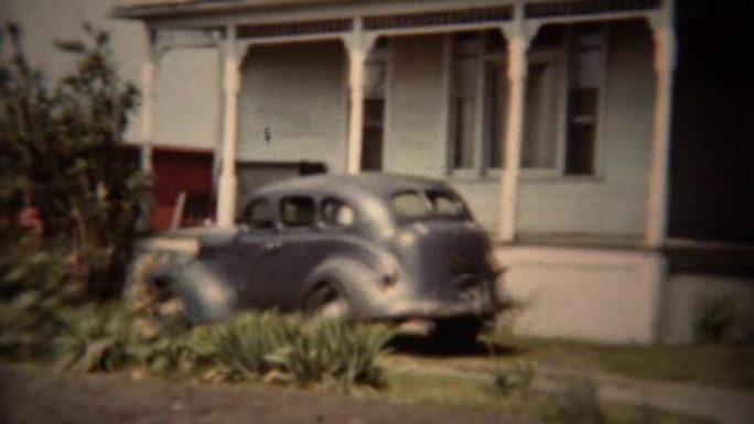 1962: 经典的灰色道奇汽车停在郊区的房子车道。