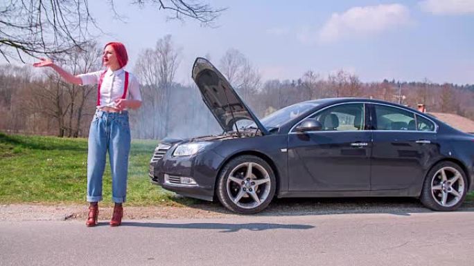 红头发的女人站在她的车前，请路过的人来帮助她拍摄一部慢动作镜头。