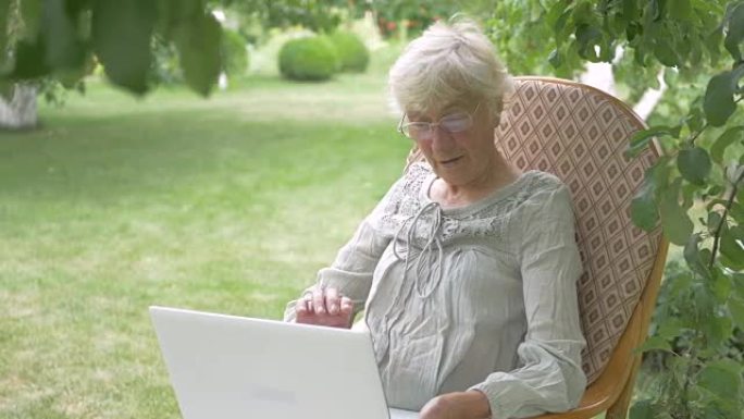 老年妇女在笔记本电脑上聊天。