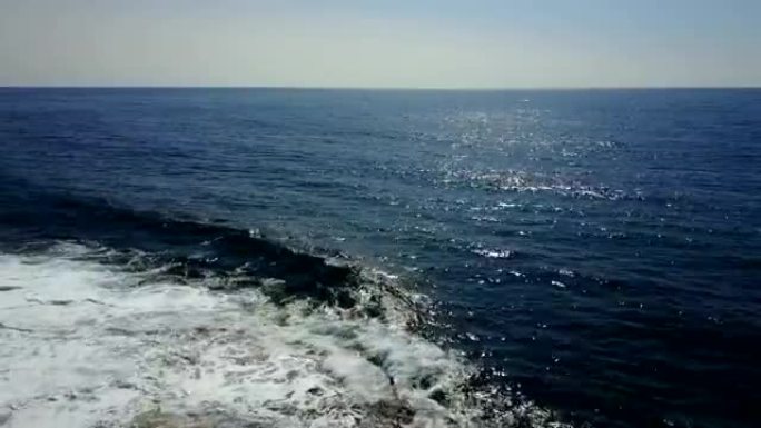 海上。海浪撞击纯石海岸。无人机的观点。清澈的蓝色清澈的水