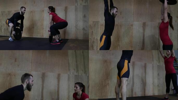 年轻运动员夫妇在健身房进行锻炼训练时举起保险杠板做运动