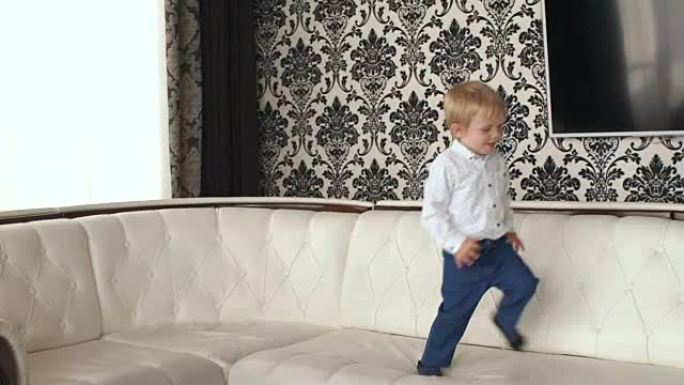 小男孩跳上白色皮沙发，慢莫。
