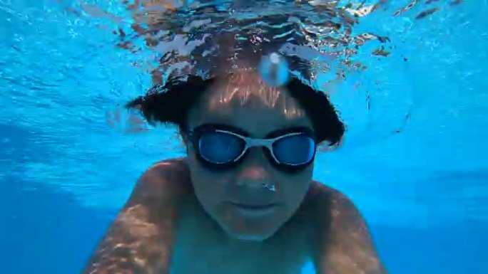 在游泳池里潜水的小男孩