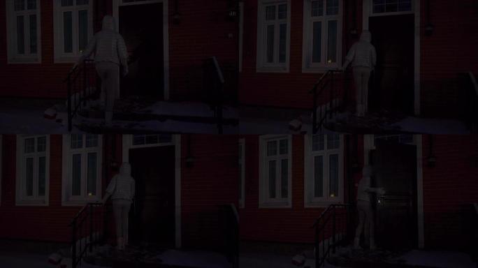穿着银色冬季夹克的女孩晚上进入联排别墅，慢动作视频