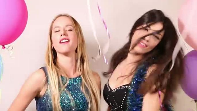 两个美女在照相亭派对上跳舞的特写镜头