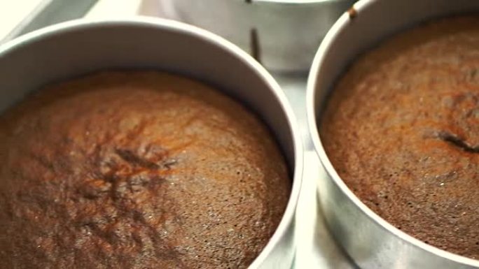 巧克力蛋糕海绵在不锈钢模具中烘烤，由烤箱新鲜制成，用于生日蛋糕