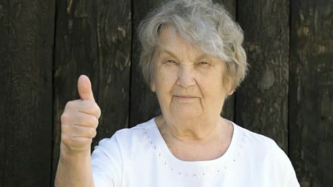 老年妇女在户外竖起大拇指