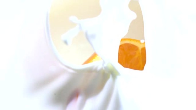 鲜白牛奶慢动作中多汁橙子滴的一半