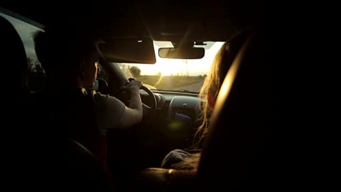 日落时坐在车里的男人和女人。