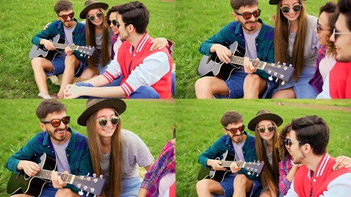 一群年轻英俊的人在野餐时，他们弹吉他和唱歌。