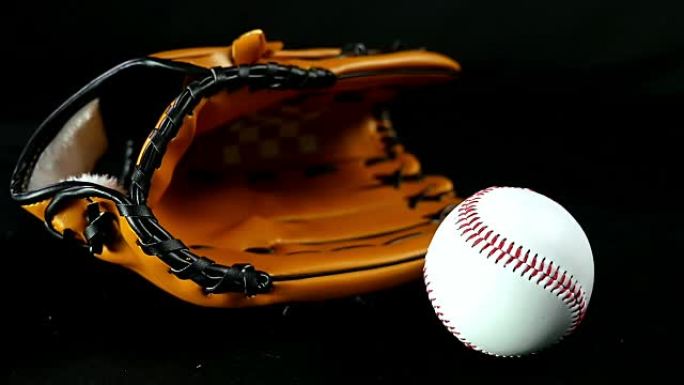 黑色背景上的棒球手套和球，慢动作