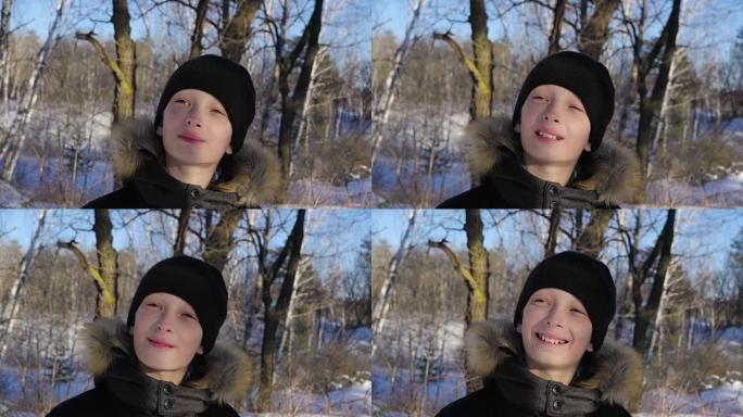一个十几岁男孩的肖像特写。这个男孩做了一张严肃的脸。森林里阳光明媚的冬夜。强风。