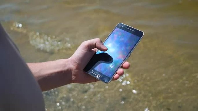 在海滩上使用智能手机的人的特写