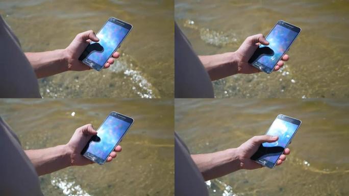 在海滩上使用智能手机的人的特写