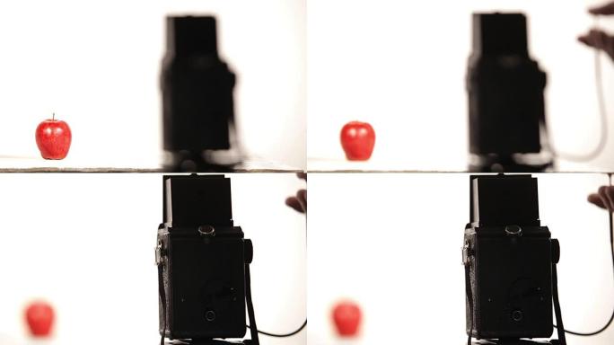 摄影师在白色工作室拍摄了一张红色的苹果照片，带有复古的中等格式