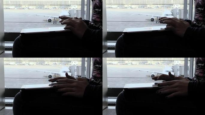 在机场使用平板电脑的女人的手