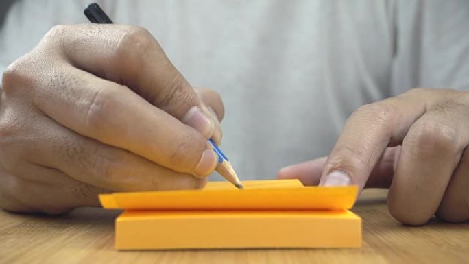 手在橙色纸上书写