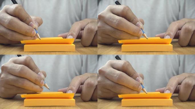 手在橙色纸上书写