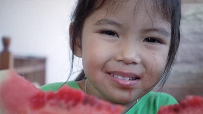 特写肖像亚洲小女孩吃西瓜，慢动作