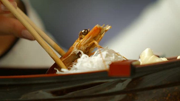 用筷子拿虾。