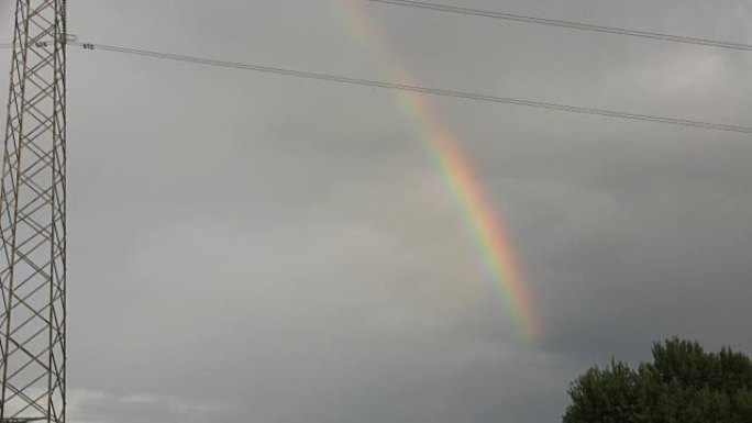 高压电杆附近多云天空中的彩虹色