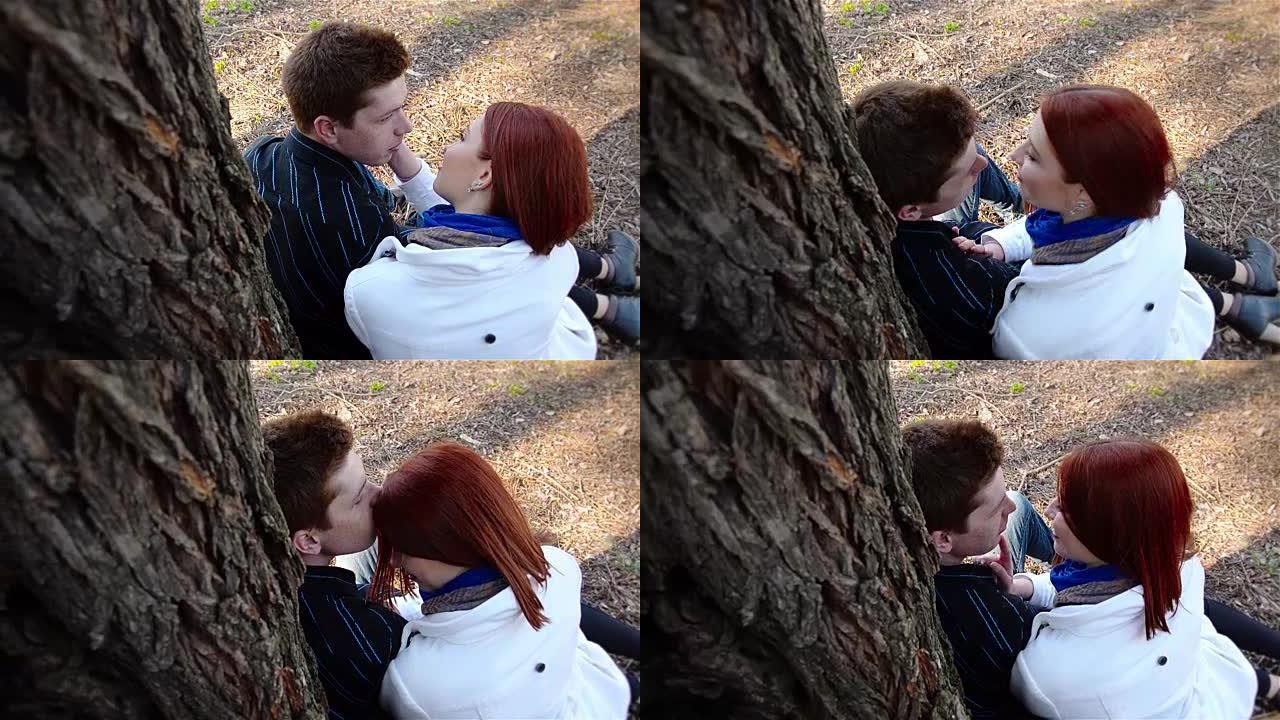 年轻人和红发女孩在树附近接吻
