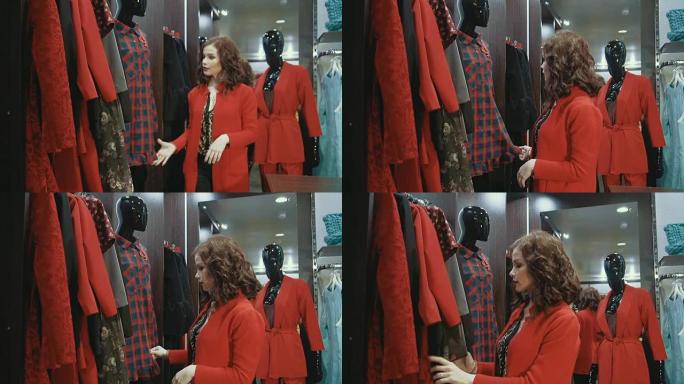 穿着红色夹克的年轻女子在商店里整理挂在衣架上的衣服。