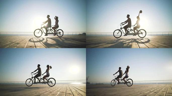 混血夫妇在海边户外双人自行车骑行的肖像，慢动作