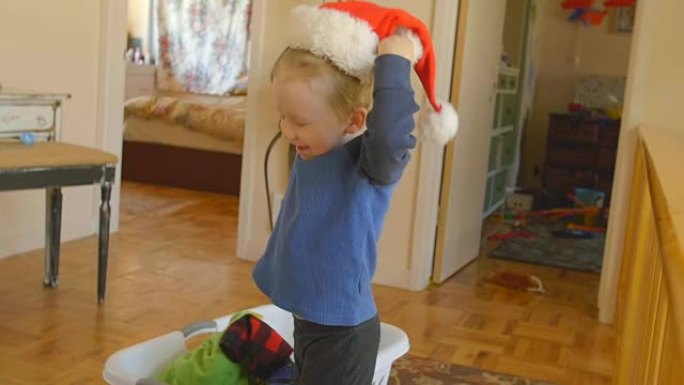 可爱的小男孩扮装戴上圣诞老人的帽子，笑着开心
