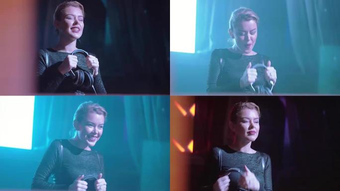 迷人的Dj女孩在夜总会舞台上的转盘上戴着耳机跳舞