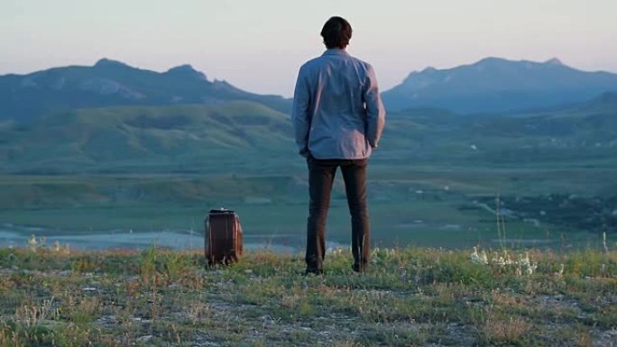 男人带着手提箱欣赏山景
