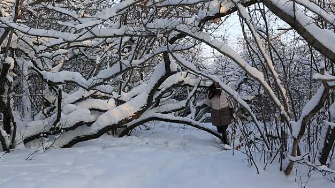 美丽受惊的女孩在白雪皑皑的森林中逃离了一个虚构的恶棍