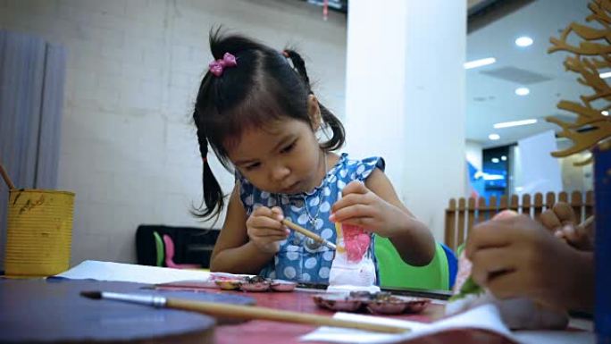 小女孩学习绘画的特写肖像用儿童手到白色石膏娃娃玩具