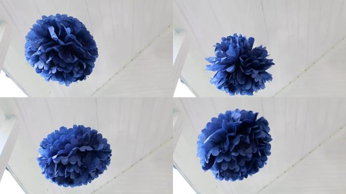 蓝色纸球在白色天花板上绕其轴旋转