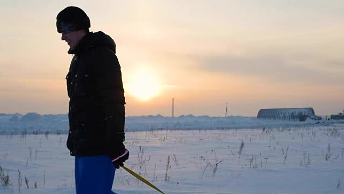 那家伙带着雪管上升到雪山。慢动作。雪冬景观。日落时间