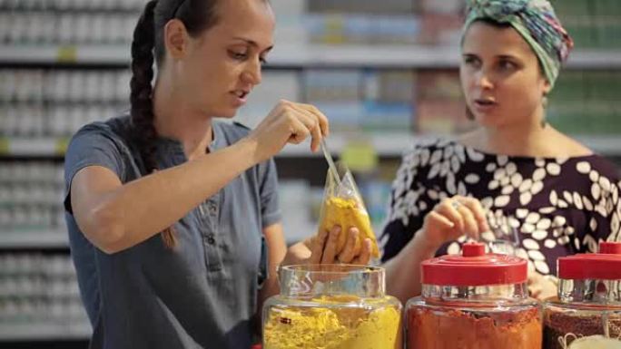 两名年轻妇女在超市的杂货店选择香料